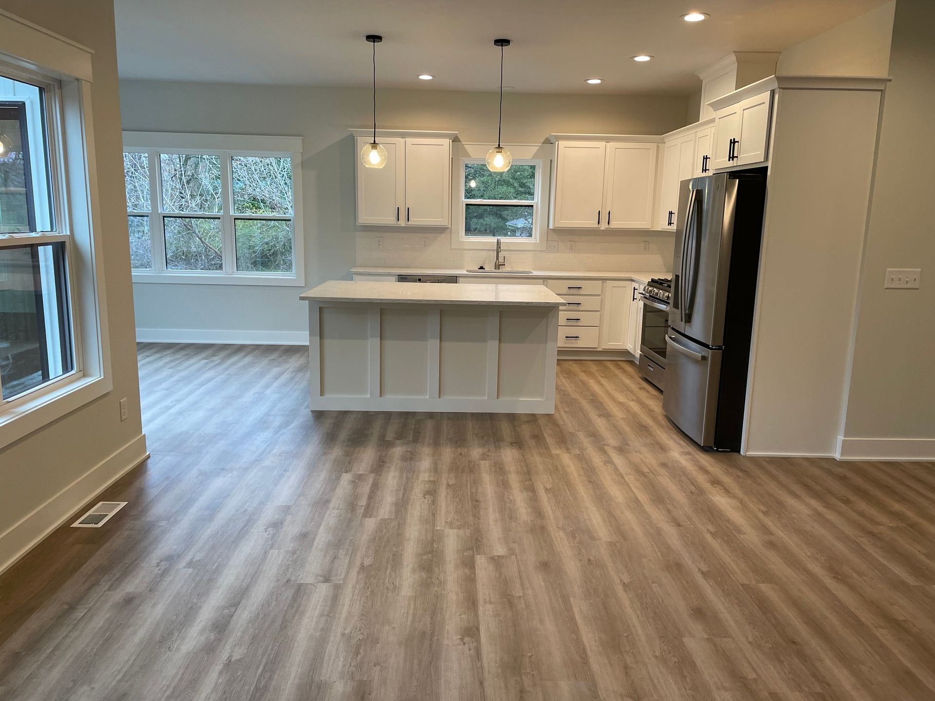 A kitchen with a large island and stainless steel appliances.
