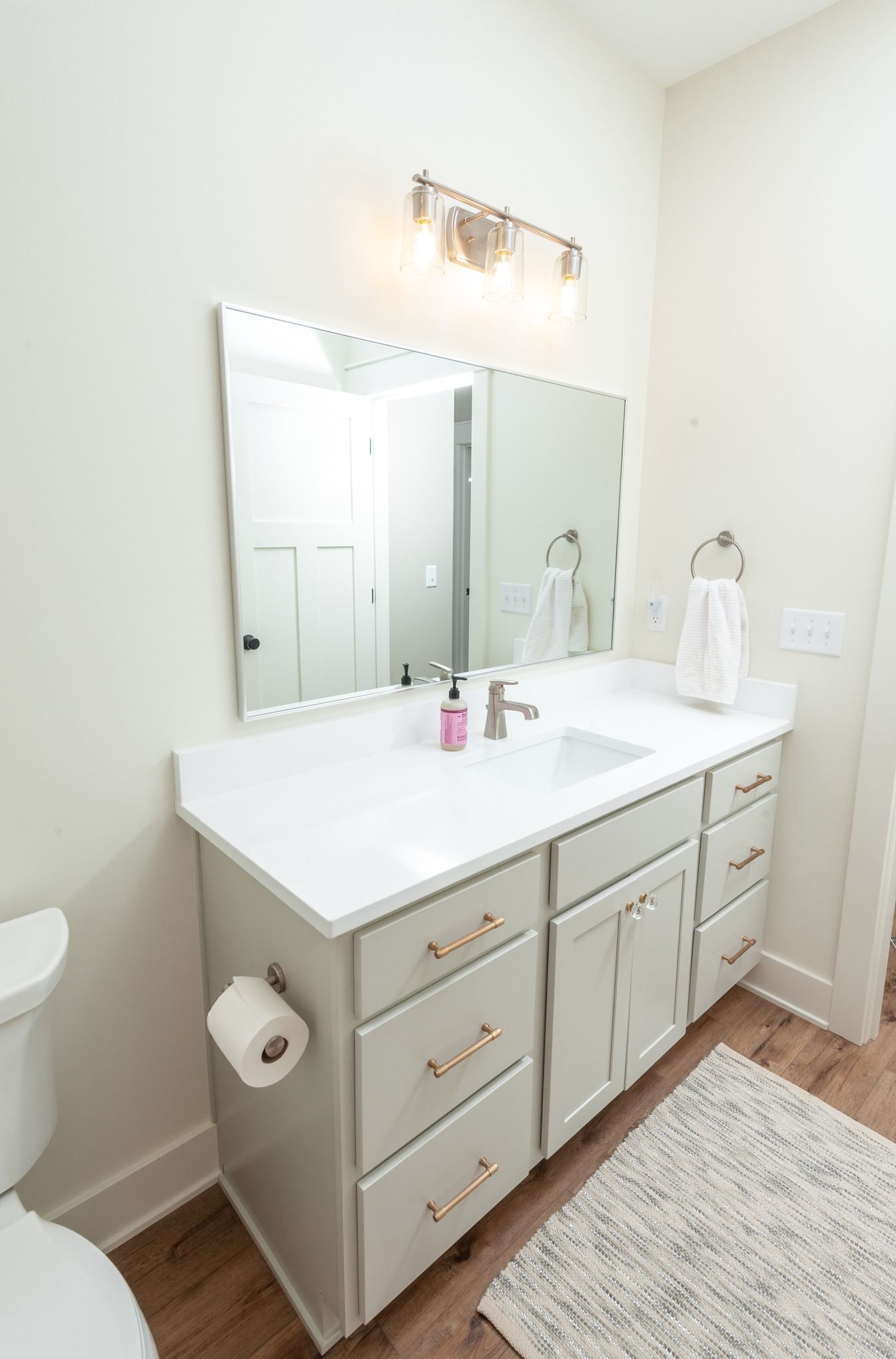 A bathroom with a sink , toilet and mirror.