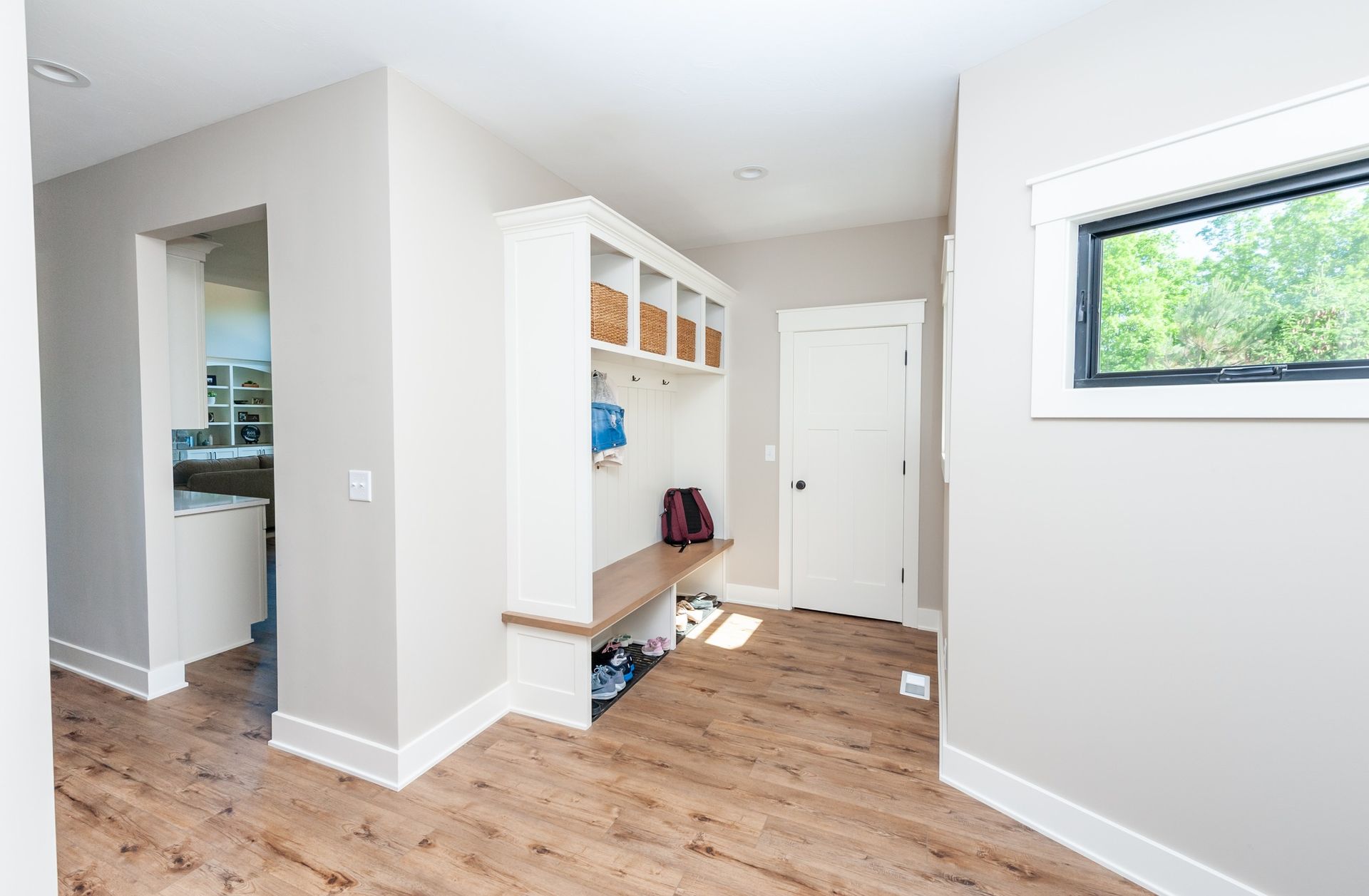 A room with hardwood floors , white walls and a window.