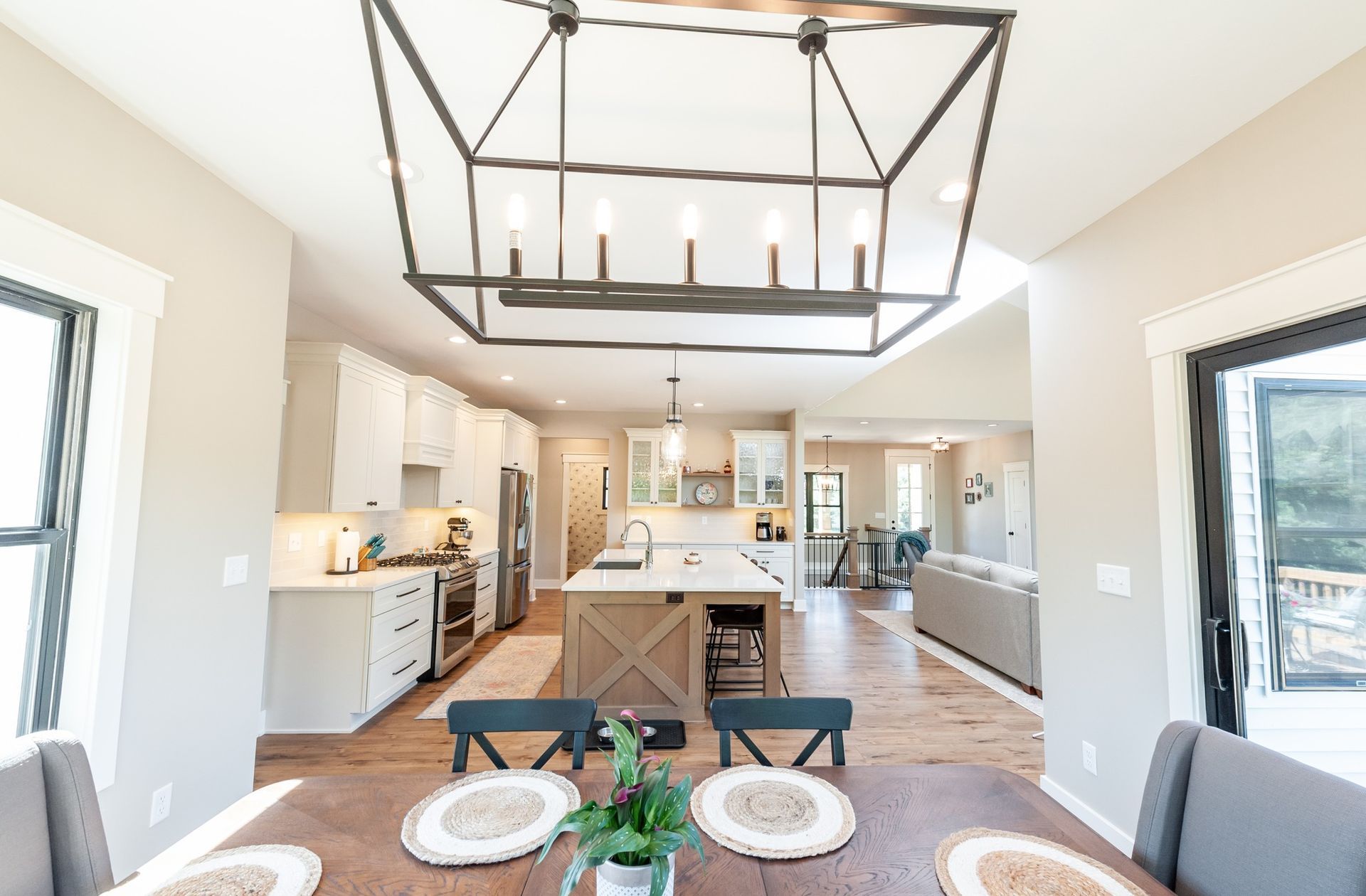 A kitchen and dining room in a house with a large chandelier hanging from the ceiling.