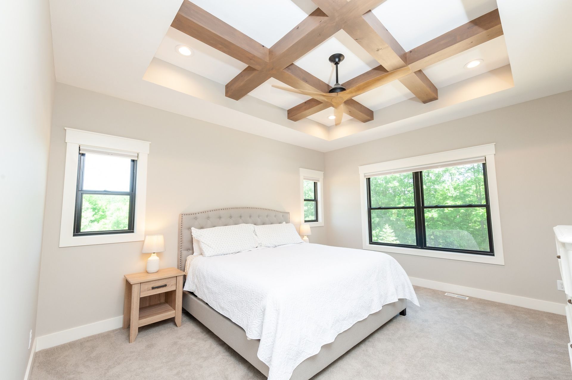 A bedroom with a king size bed and a ceiling fan.