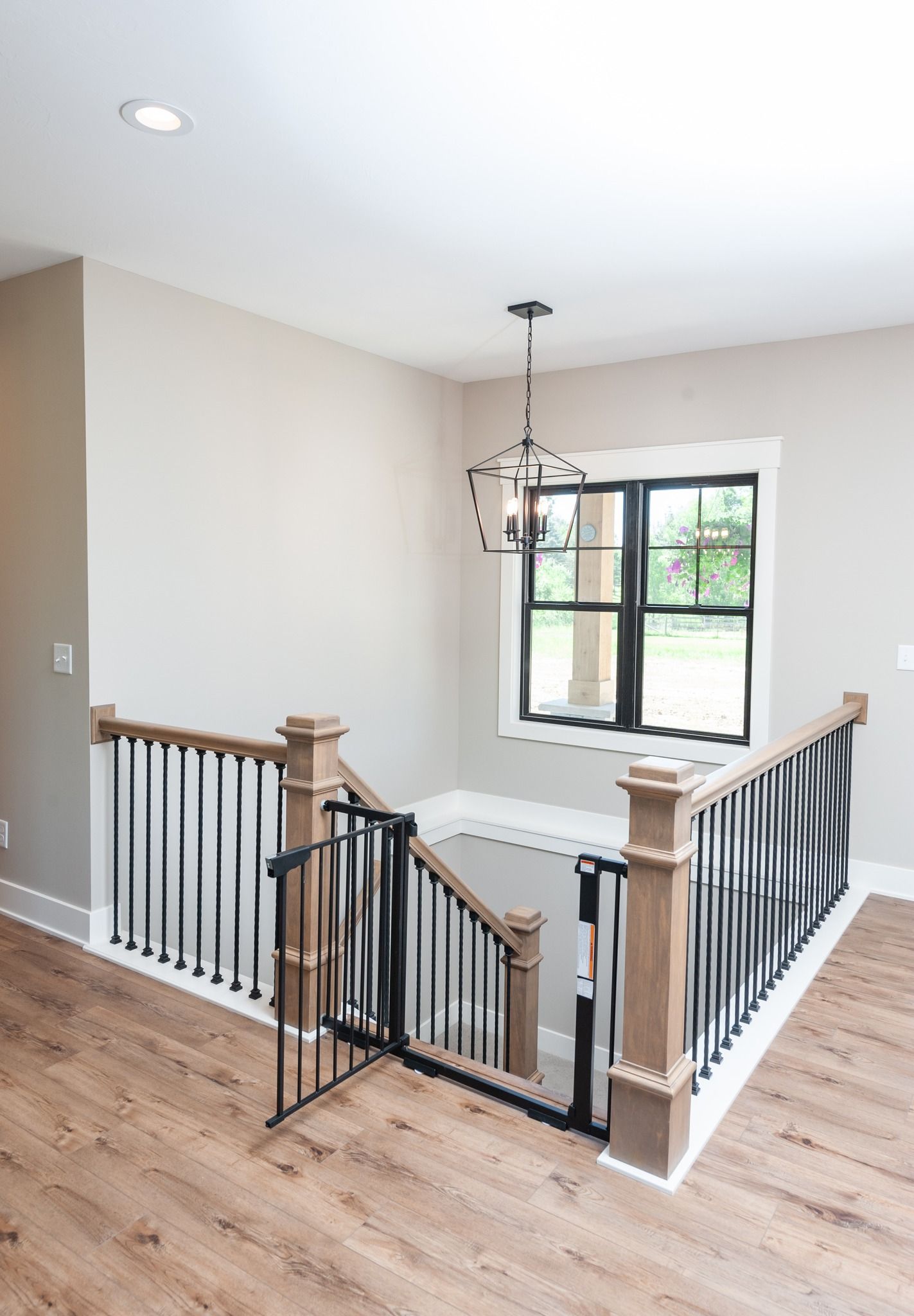 A staircase with a wooden railing and a window in a house.