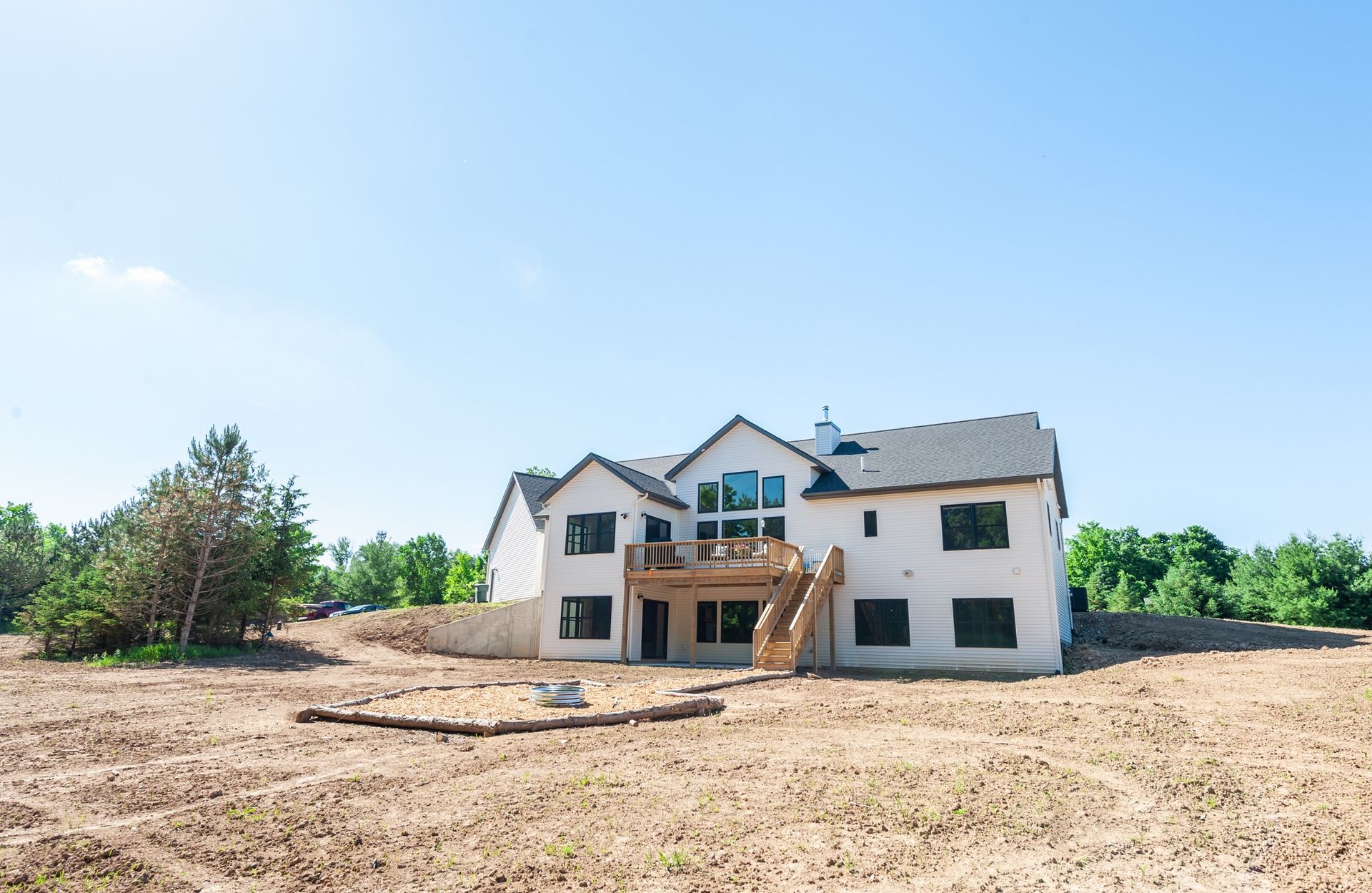 A large white house is sitting on top of a dirt hill.
