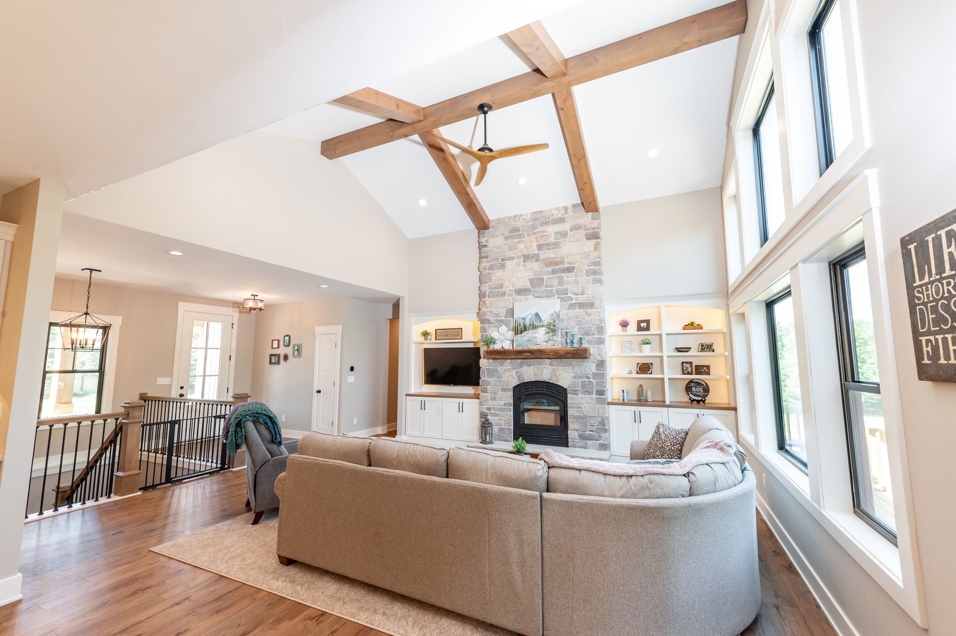 A living room with a large sectional couch and a fireplace.