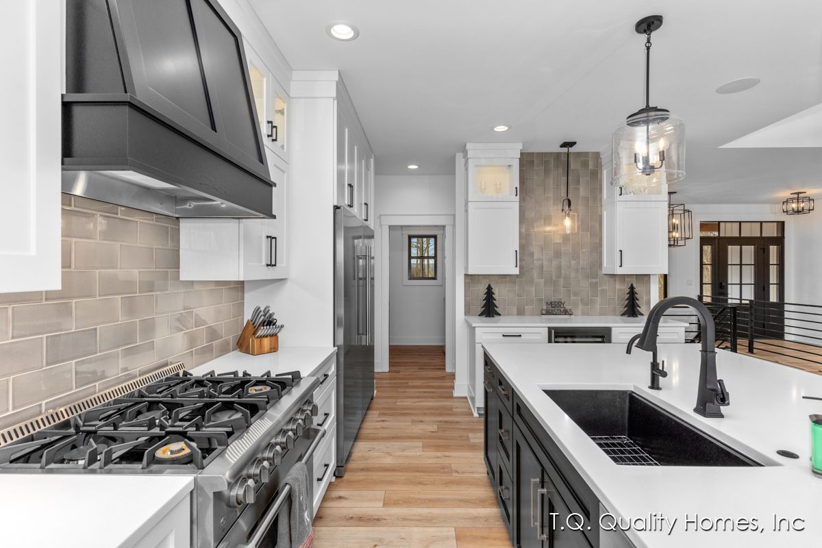A kitchen with a stove , sink , and refrigerator.