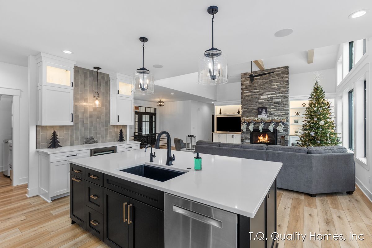 A kitchen with a large island and a christmas tree in the background.
