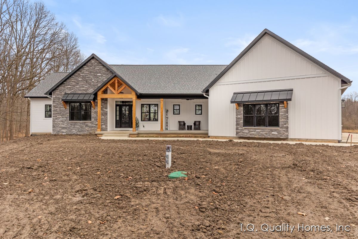 A large house is sitting on top of a dirt field.