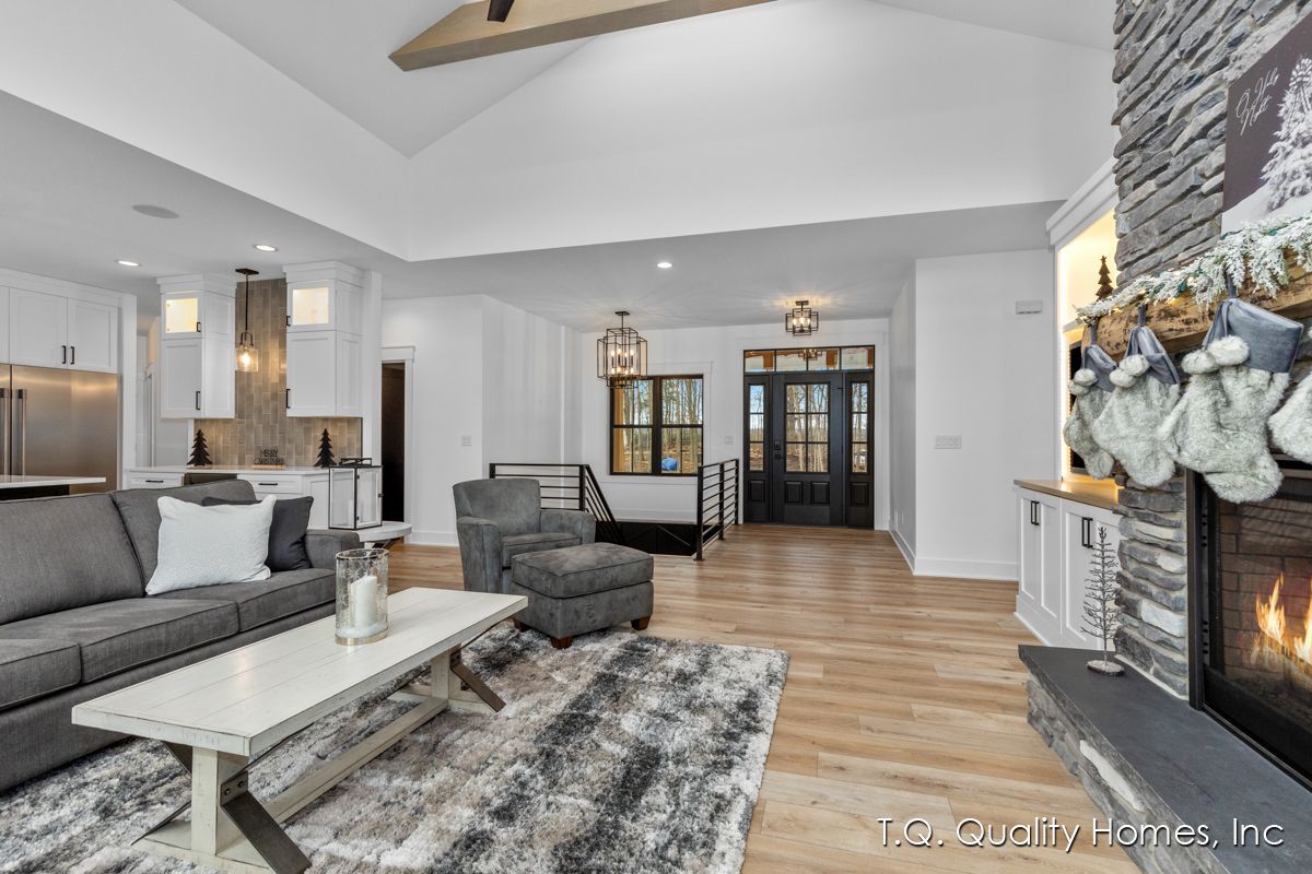 A living room with a couch , chair , coffee table and fireplace.