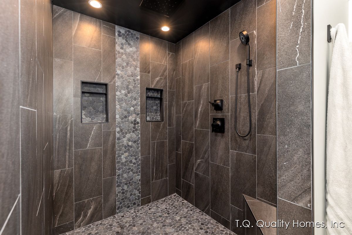 A bathroom with a walk in shower and a shower head.