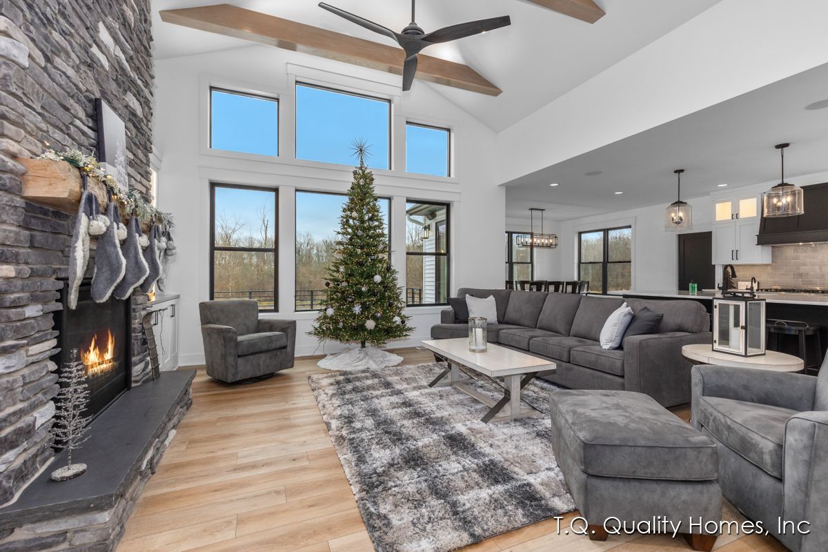 A living room with a couch , chairs , a fireplace and a christmas tree.