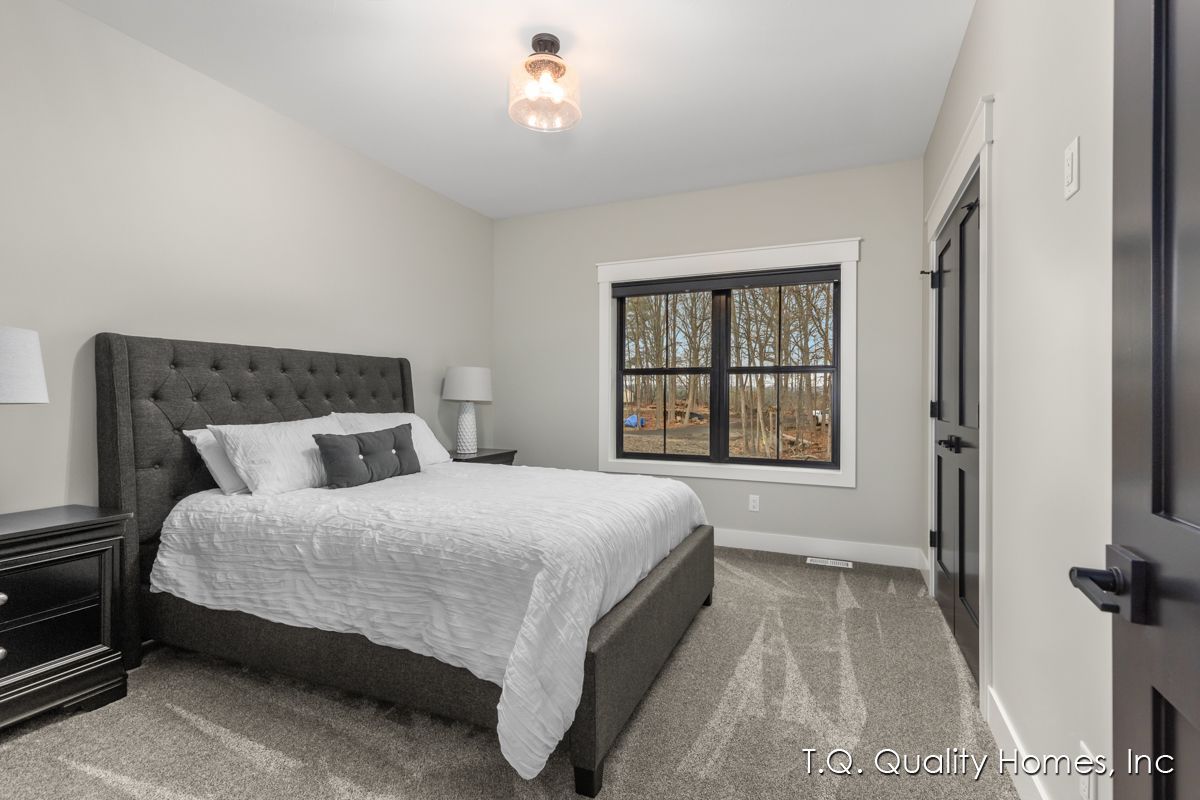 A bedroom with a large bed and a window.