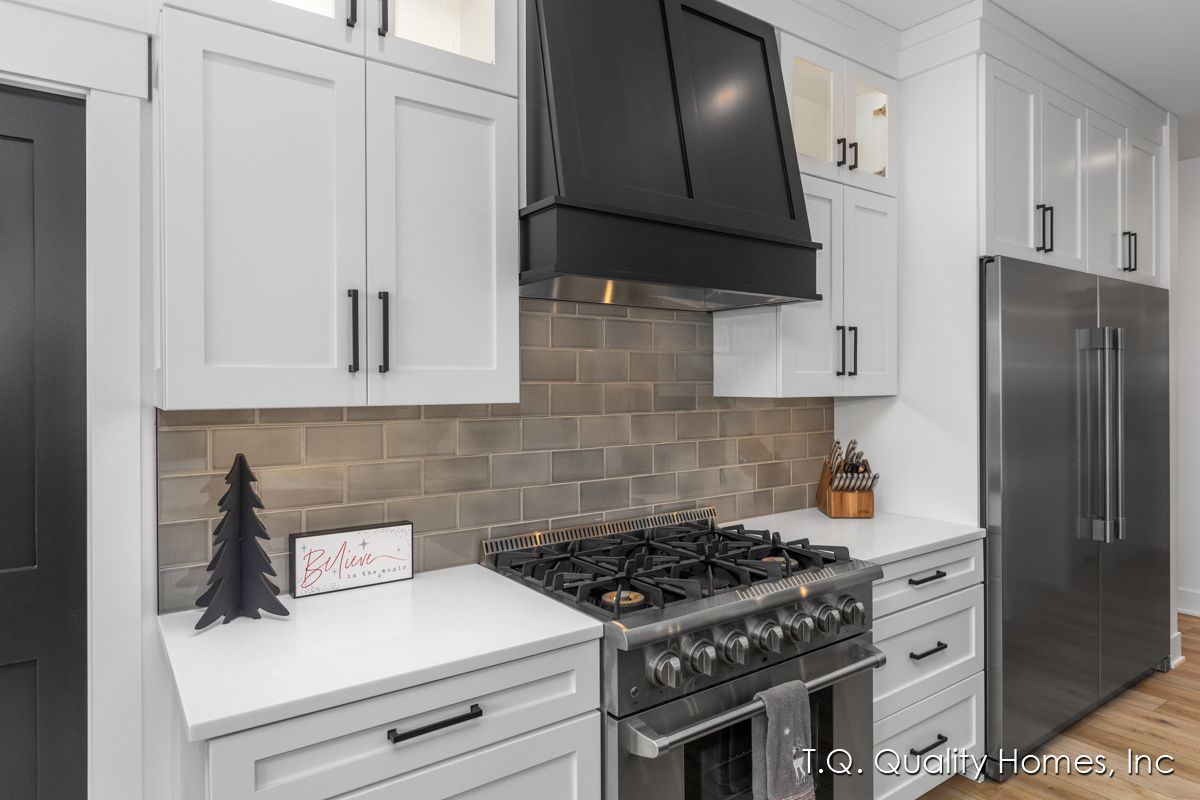 A kitchen with white cabinets and stainless steel appliances.