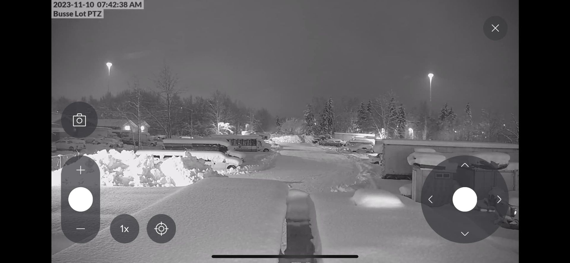 Snowy street scene at night, lit by streetlights. Control buttons overlayed at bottom.
