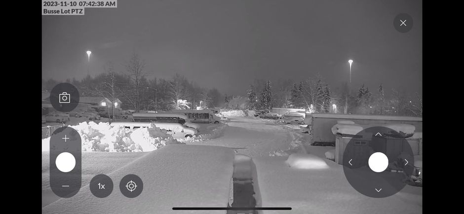 Snowy street scene at night, lit by streetlights. Control buttons overlayed at bottom.