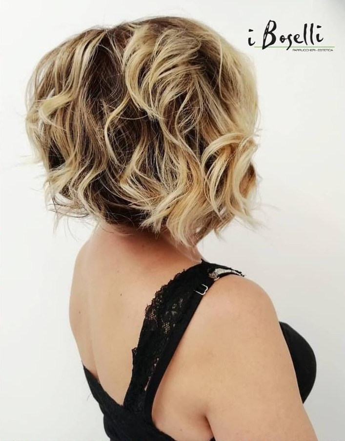 Piatto di pasta con tagliatelle scure, salsa cremosa ed erbe aromatiche, servito in una ciotola bianca.