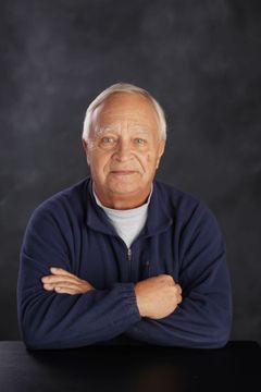 Rick Angell sits at a table with his arms crossed