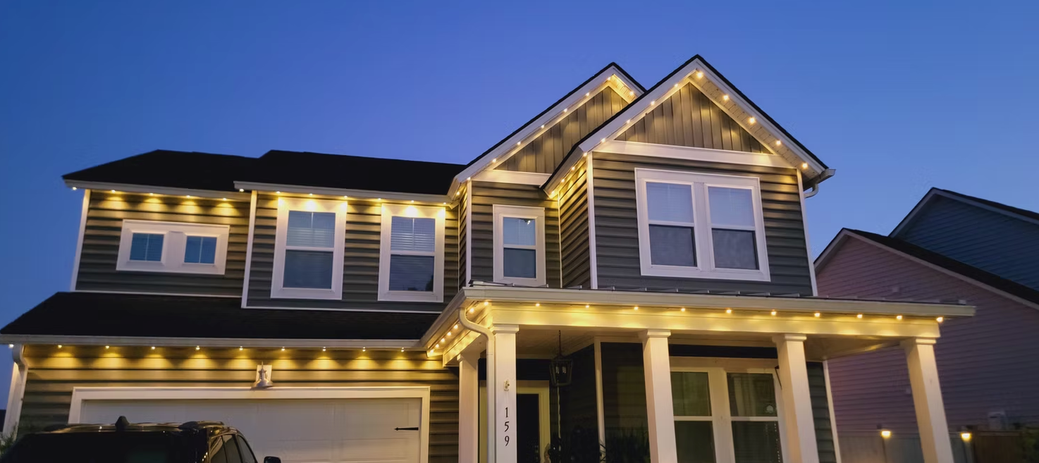 A beautiful home in Bourbonnais, Illinois at dusk with Omni permanent lights glowing in a soft warm 