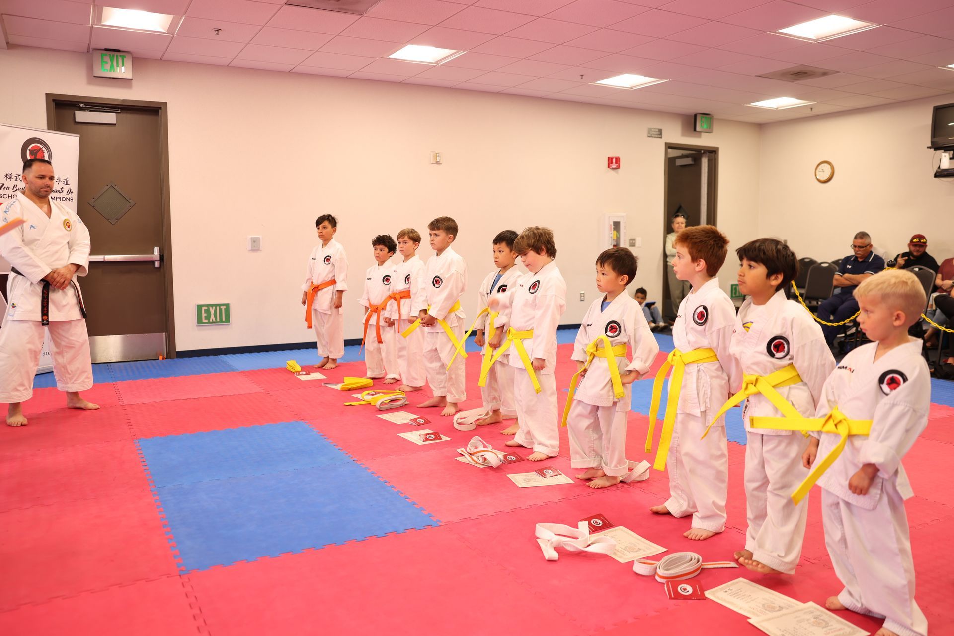 A group of young boys in karate uniforms are standing in a line.