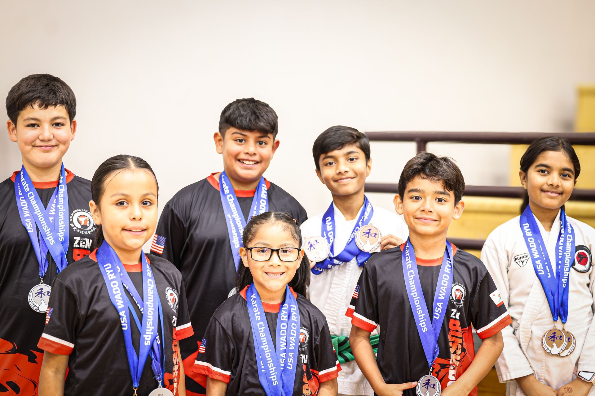 A group of children are posing for a picture with medals around their necks.