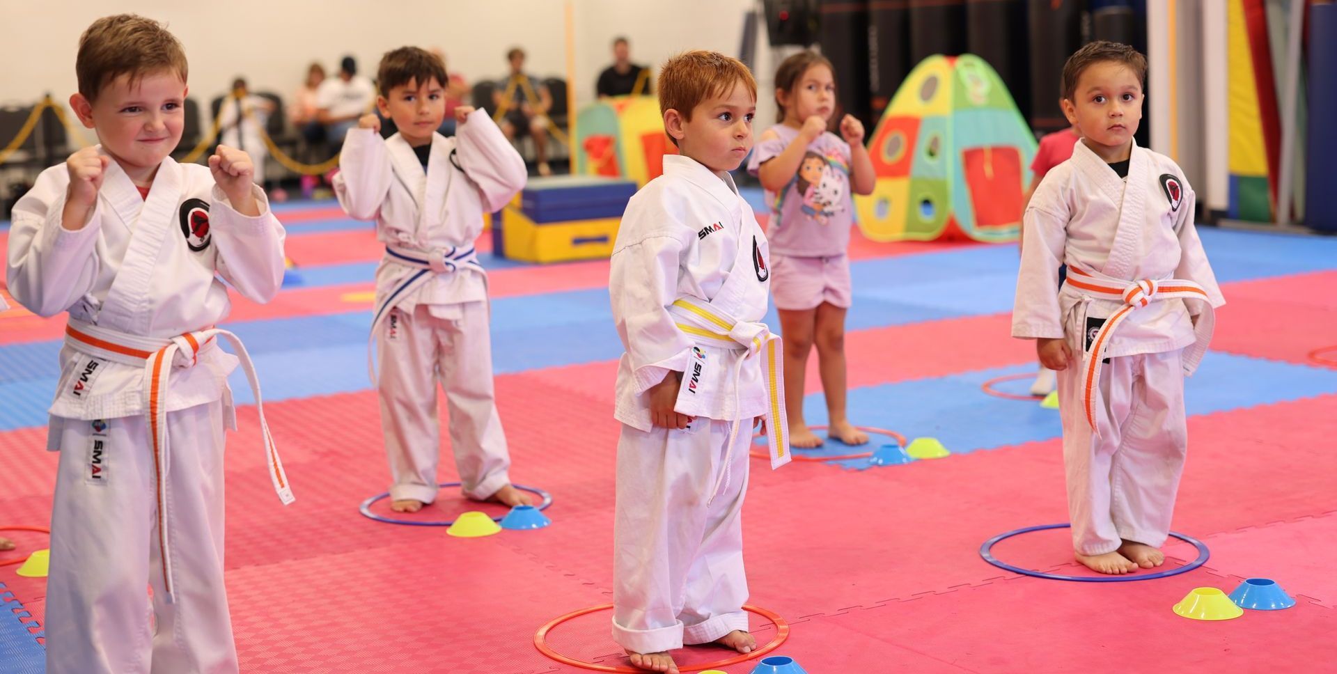 A group of children are practicing karate in a gym in La Mirada