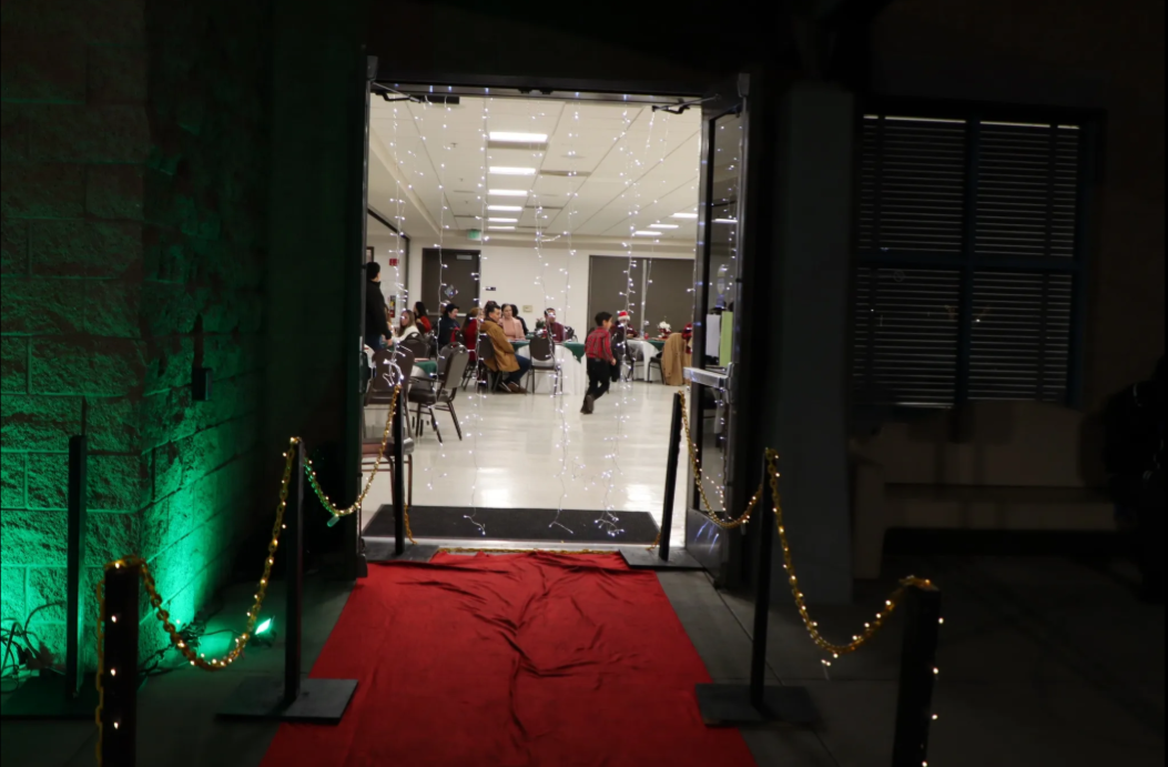 A red carpet is leading to a room with people sitting at tables.