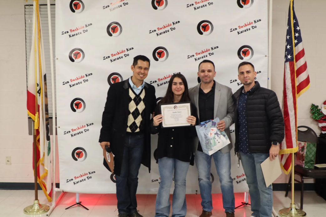 A group of people standing in front of an american flag holding a certificate.