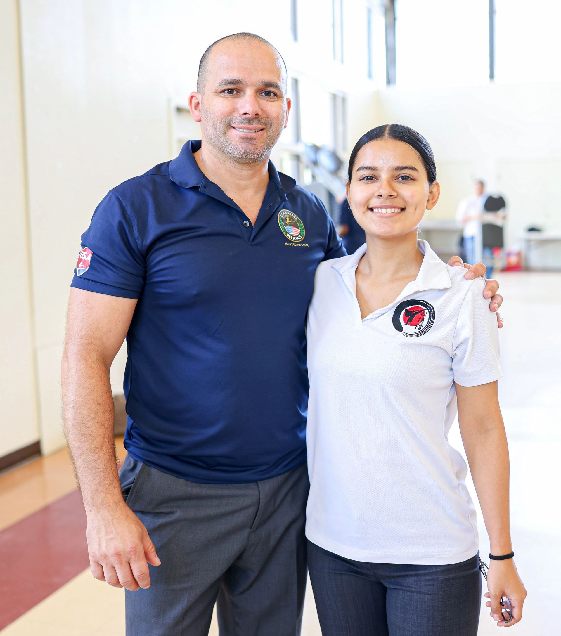 A man and a woman are posing for a picture in a gym.