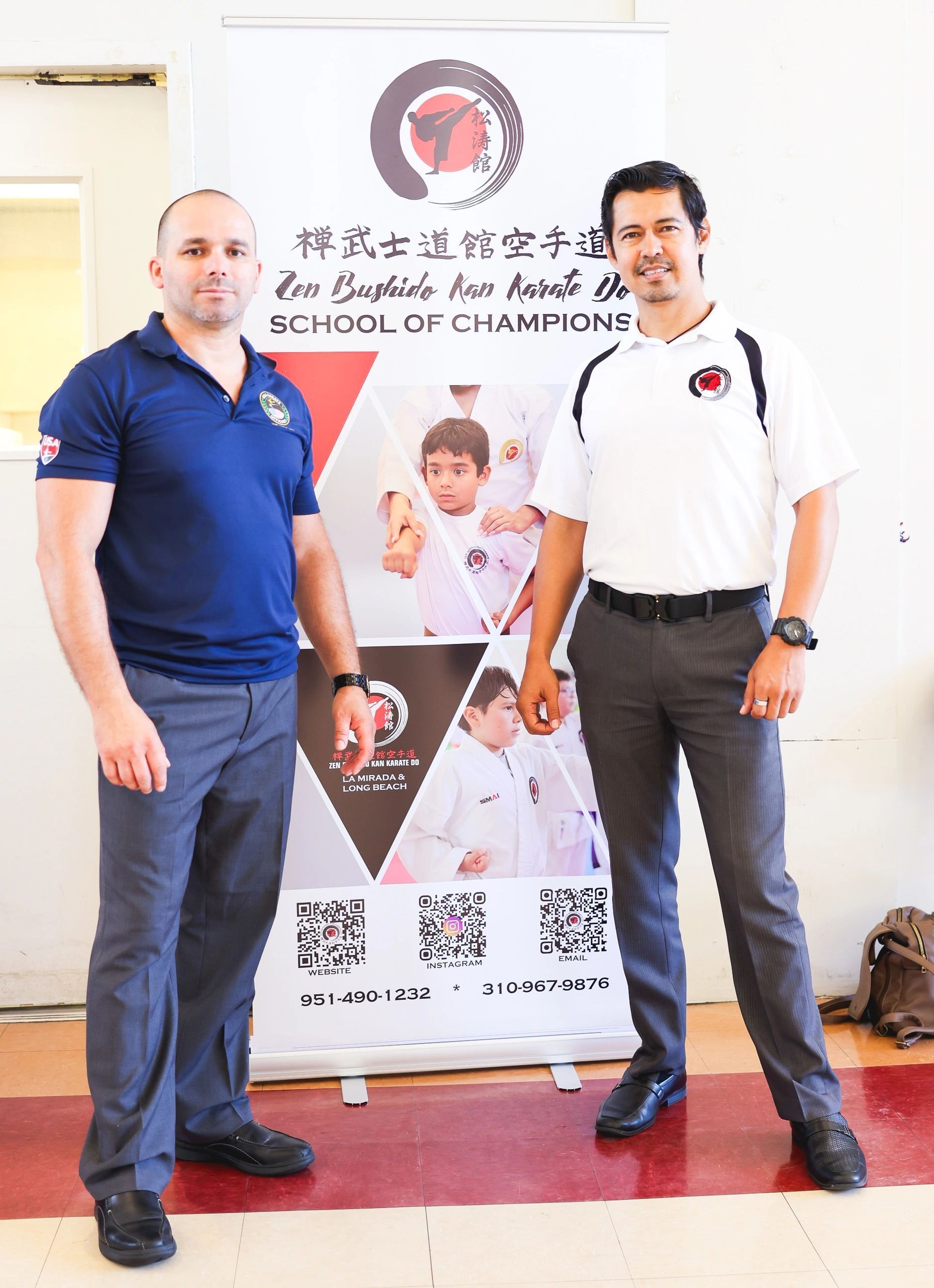 Two men are standing next to each other in front of a sign that says school of champions.