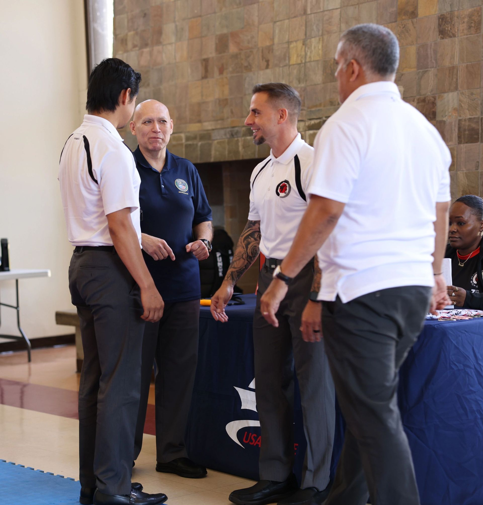 A group of men are standing in front of a table with a u on it