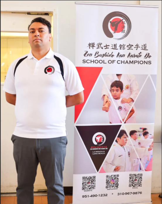 A man is standing in front of a school of champions banner
