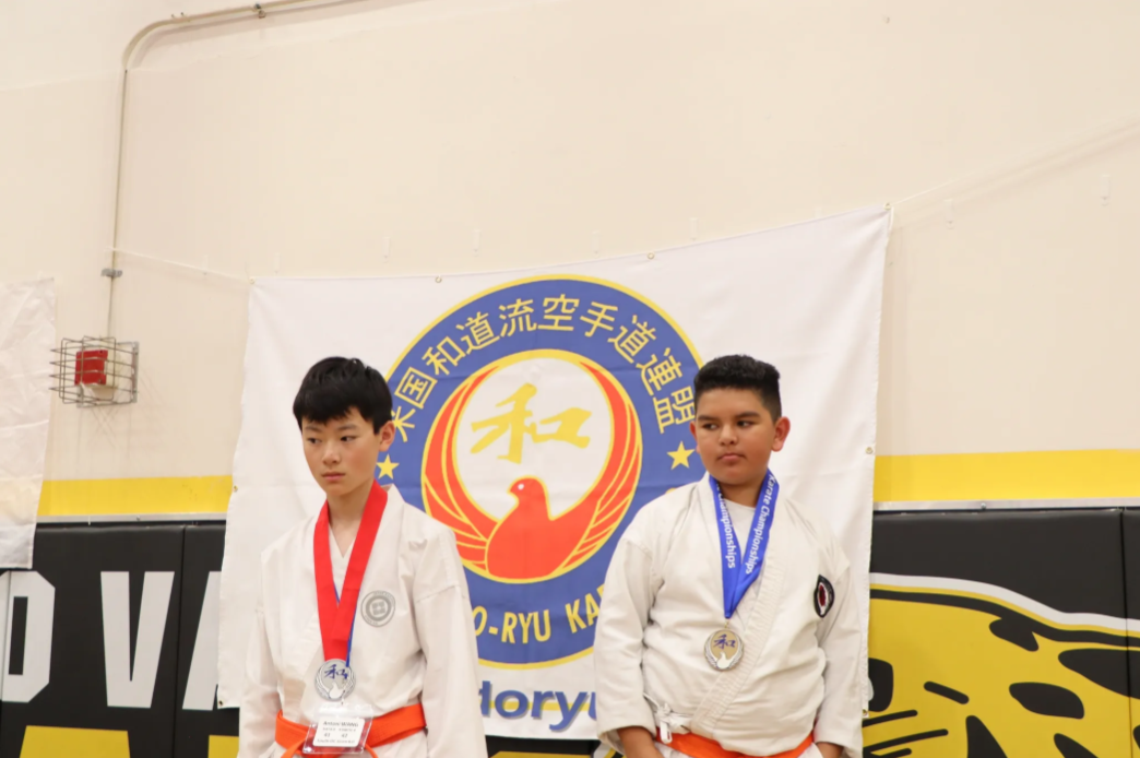 Two men are standing in front of a lory flag