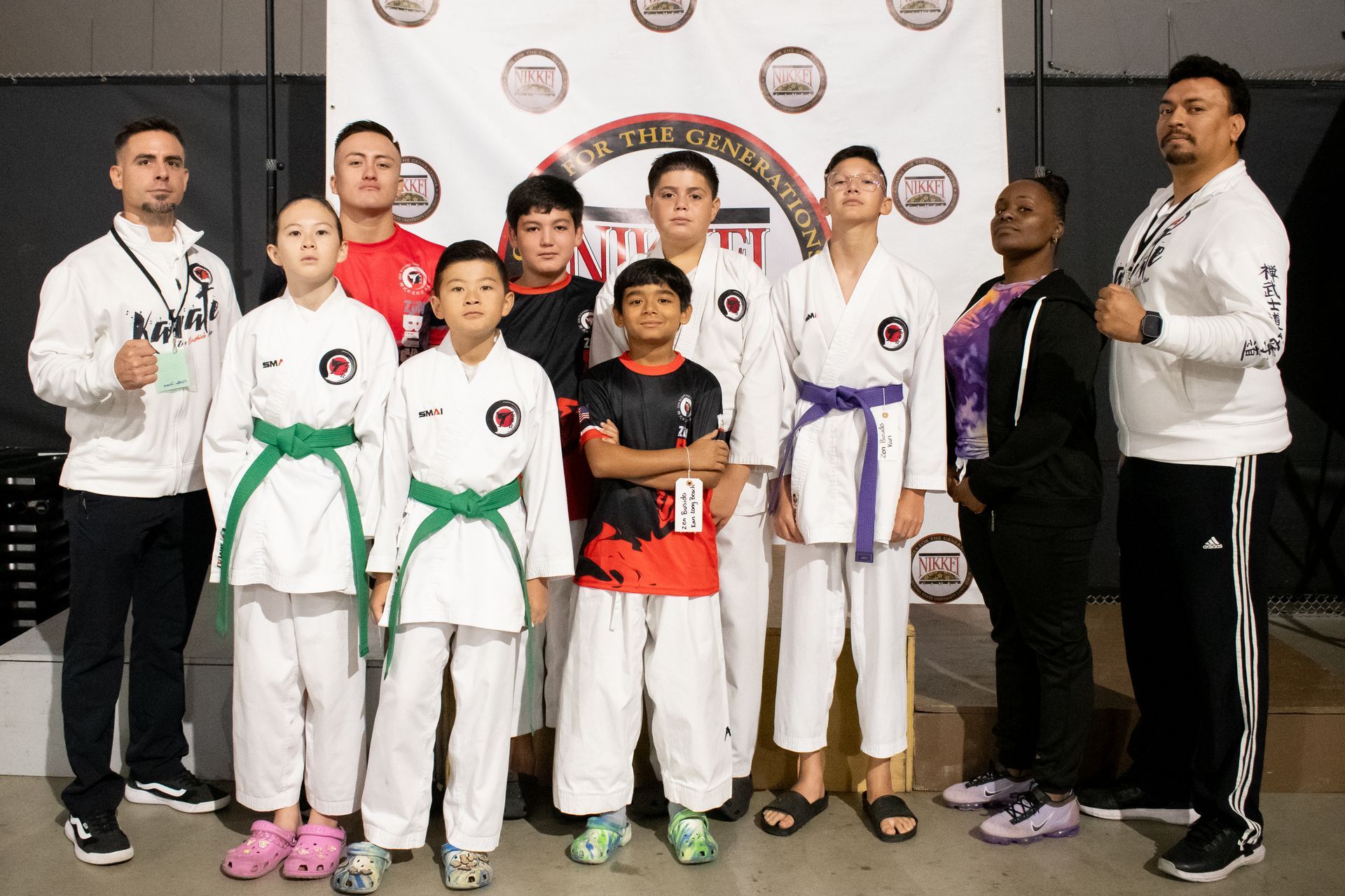 Group of karate students and instructors posing after a competition.