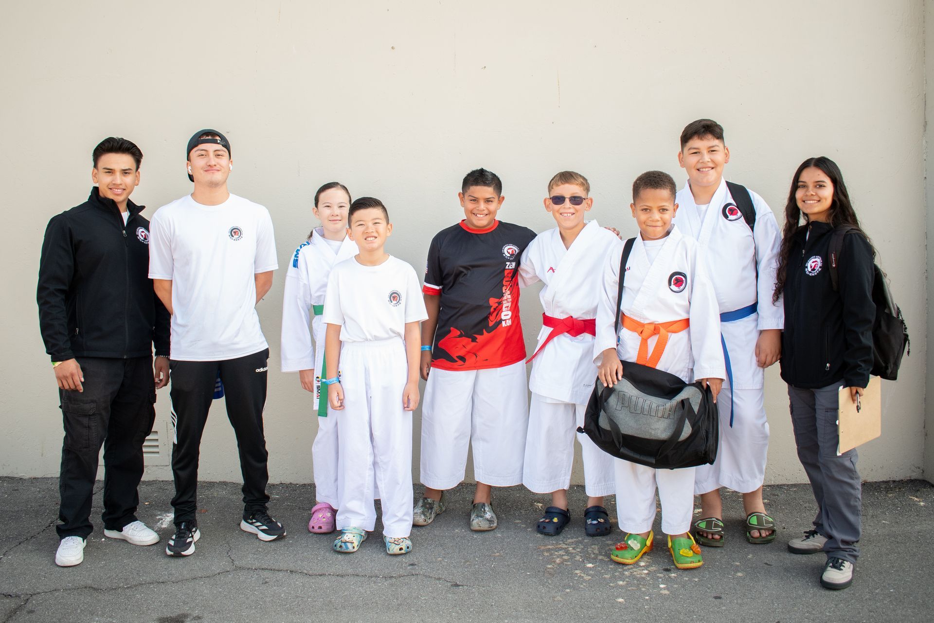 A group of young people in karate uniforms are posing for a picture.
