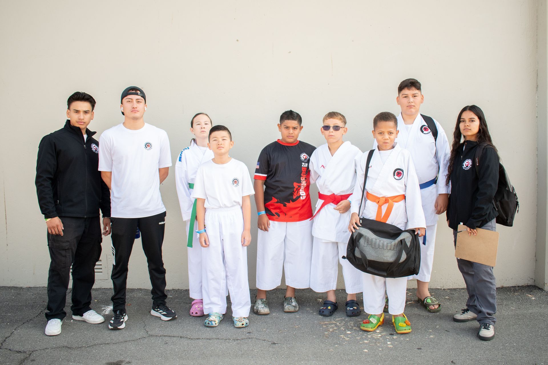 A group of young people in karate uniforms are posing for a picture.