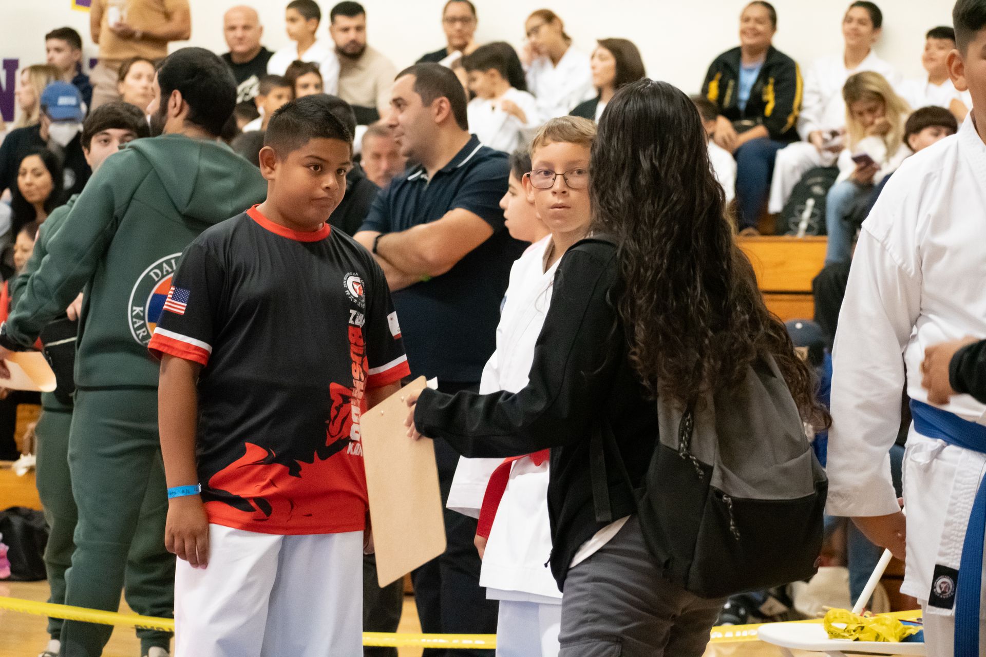 A group of people are standing in a gym.