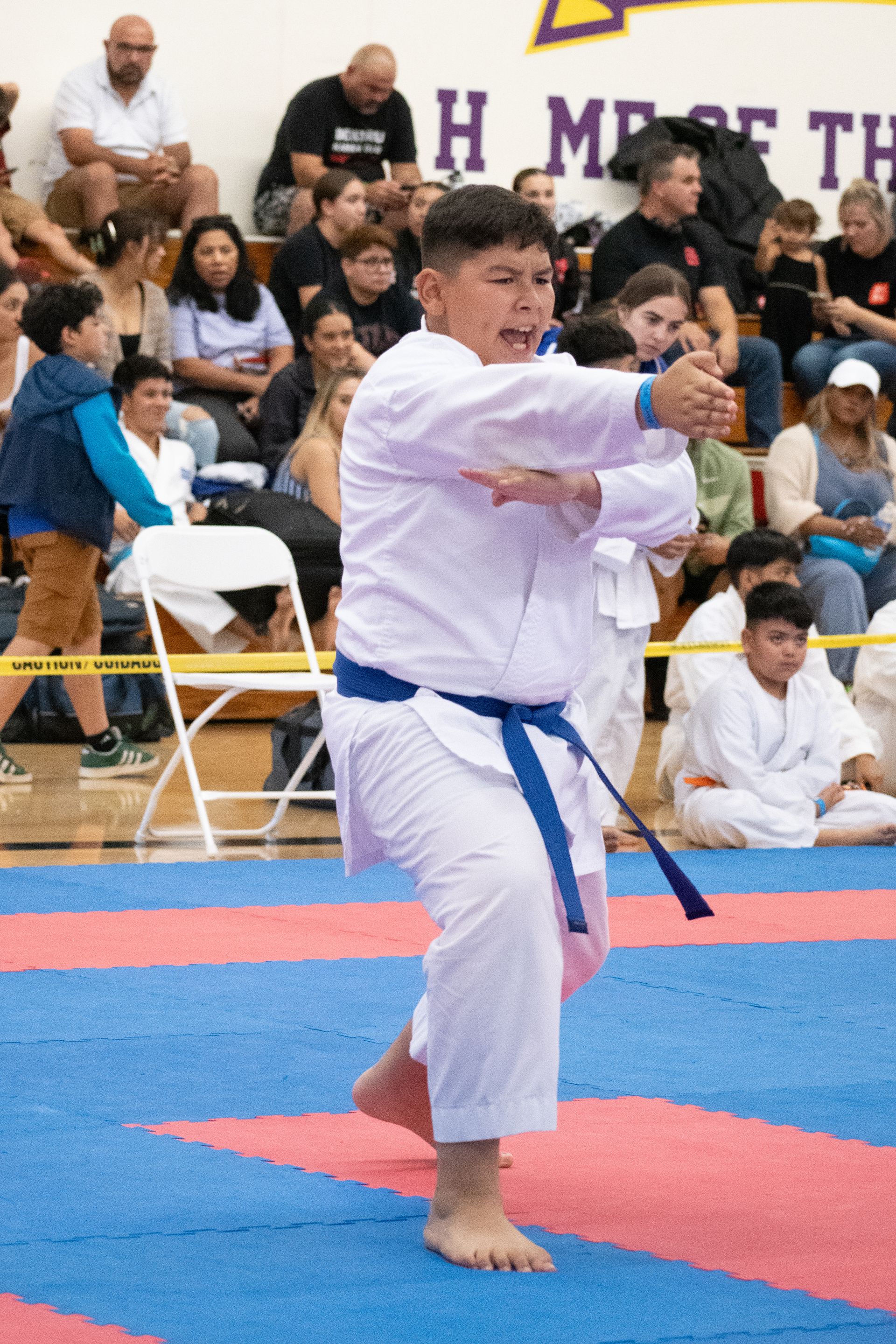 A boy in a white karate uniform with a blue belt