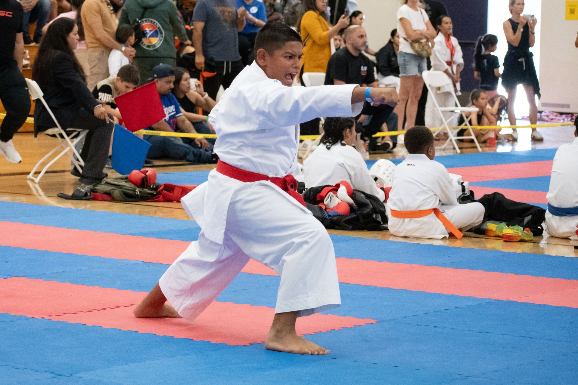 A person in a white karate uniform with a red belt