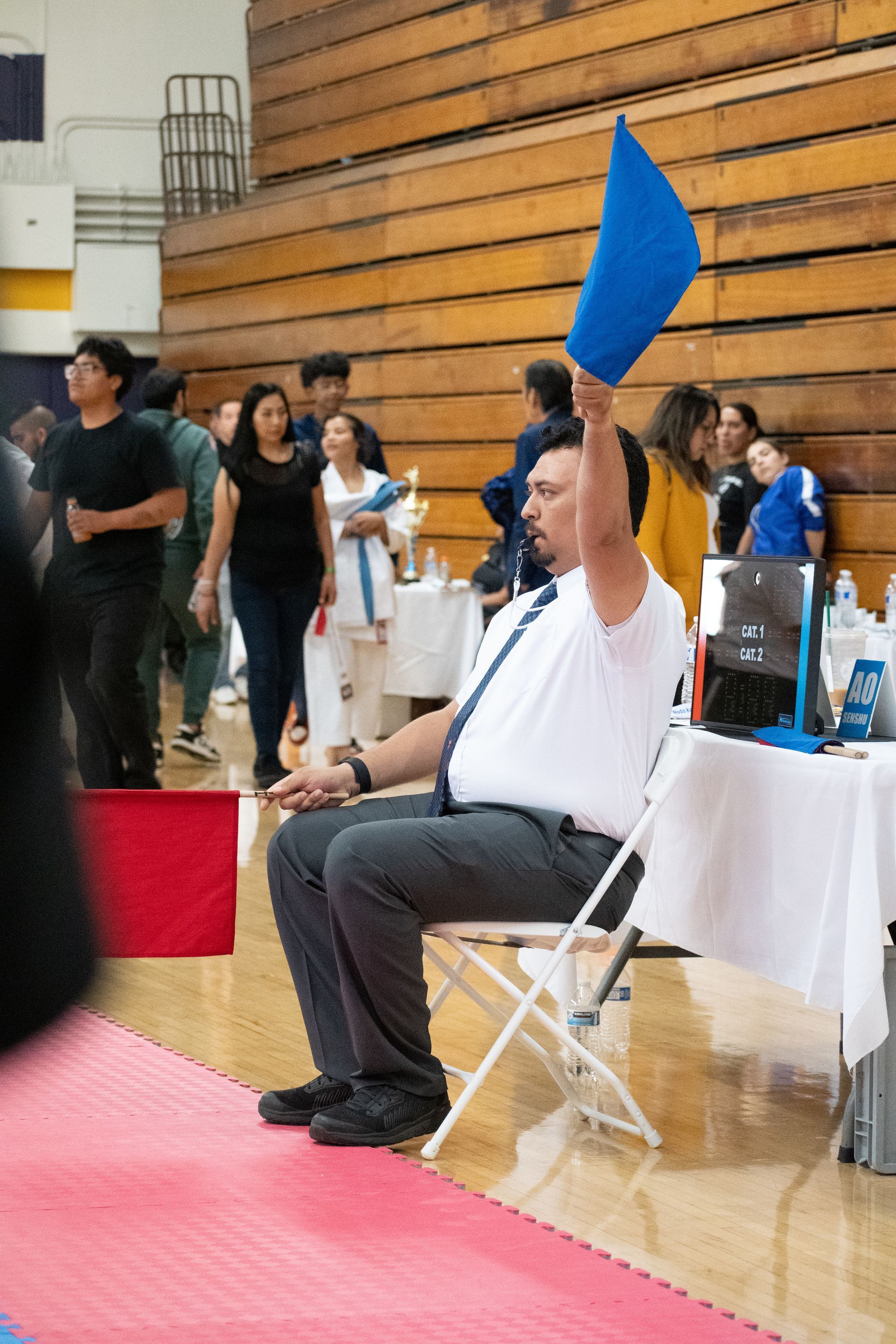 A man is sitting in a chair holding a blue flag.