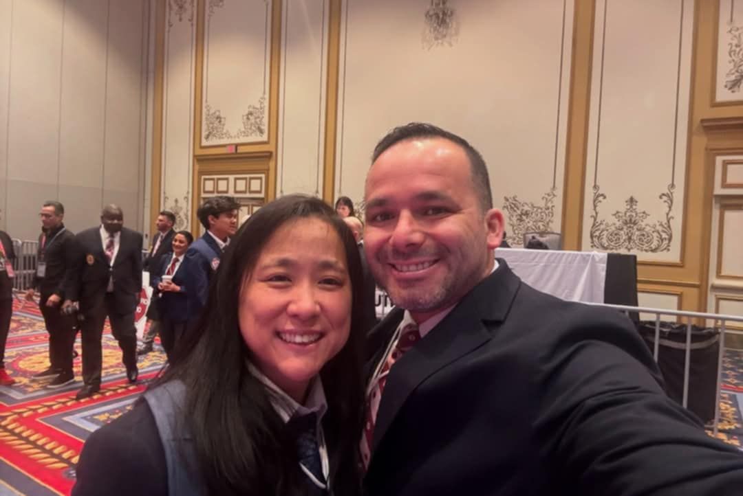 A man and a woman are posing for a picture in a room.