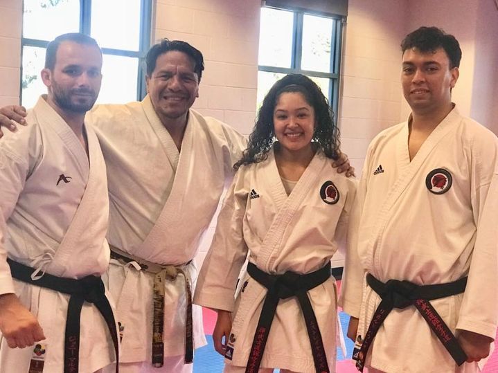 A group of people in karate uniforms are posing for a picture.