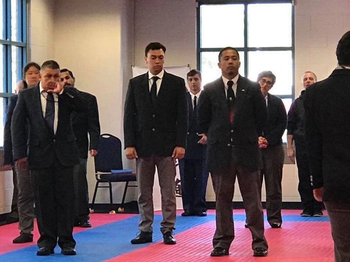 A group of men in suits and ties stand in a room