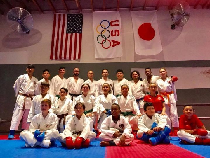 A group of people are posing for a picture in front of a flag that says usa