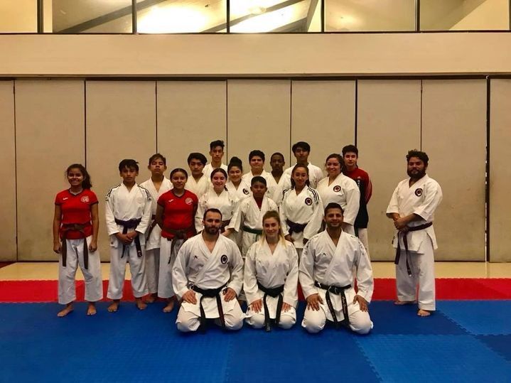 A group of people in karate uniforms are posing for a picture.