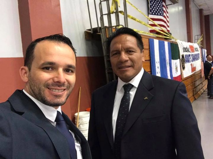 Two men in suits and ties are posing for a picture