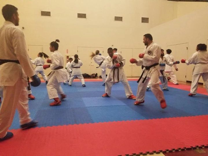 A group of people are practicing martial arts in a gym