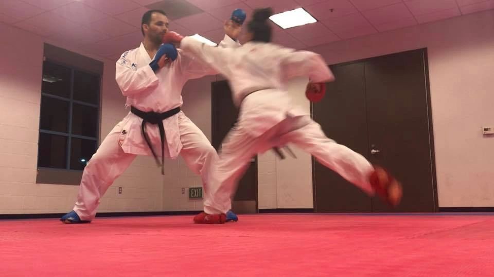 Two men are practicing karate in a gym.