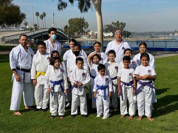 A group of people in karate uniforms are posing for a picture