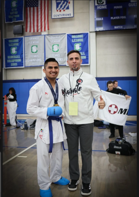 Two men are posing for a picture and one has a medal around his neck