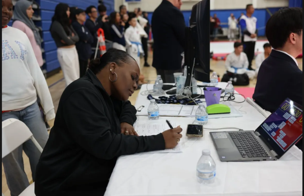 A woman is sitting at a table with a laptop on it