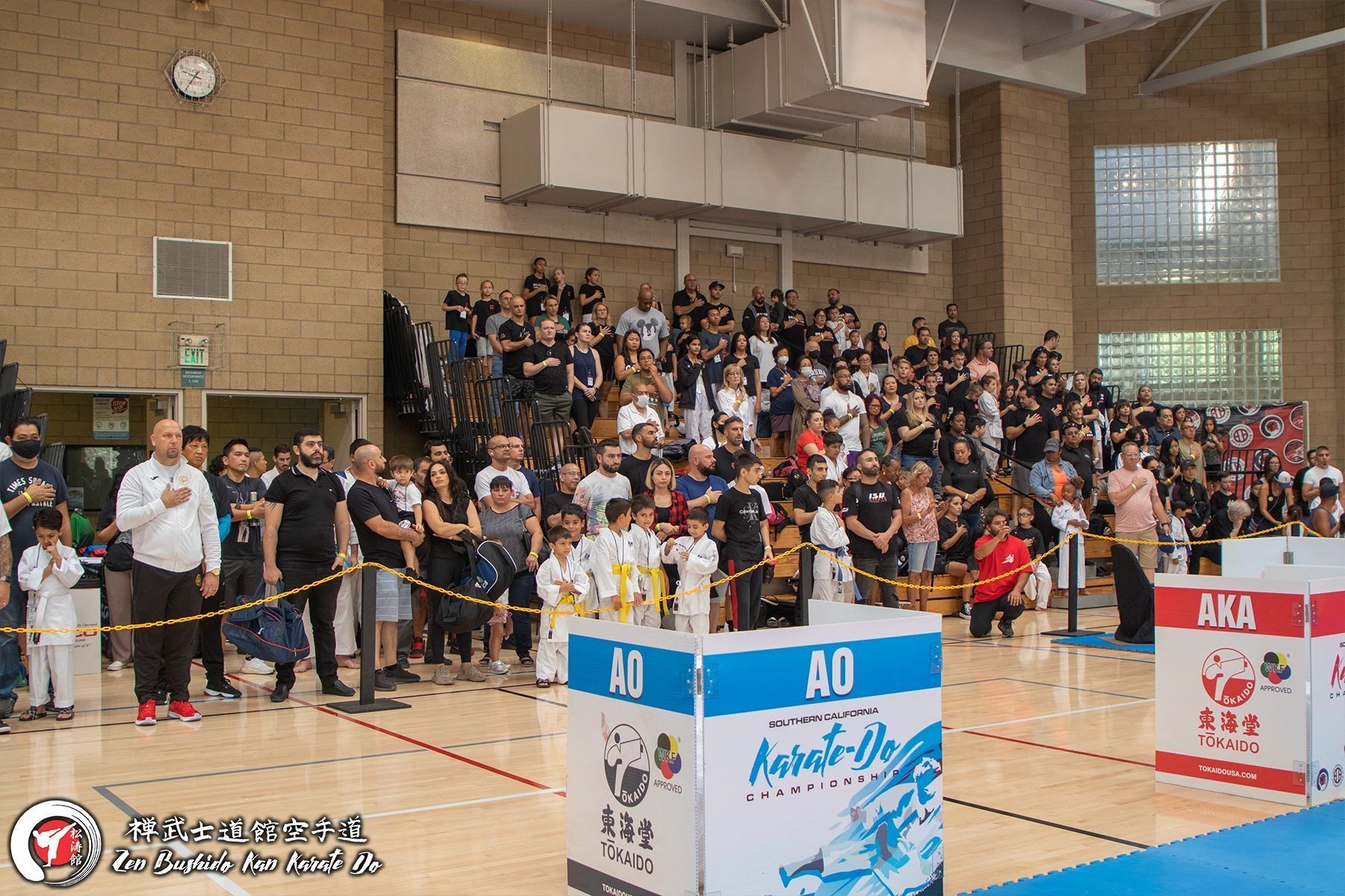 A large group of people are standing in a gym.
